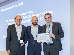 Klaus Decker (li), Geschäftsführer vom Leuze-Verlag, überreichte Christoph Kiesl (Mitte) die Silbermünze. Prof. Dr. Andreas Bund (re) überreichte den symbolischen Scheck sowie die Urkunde. 